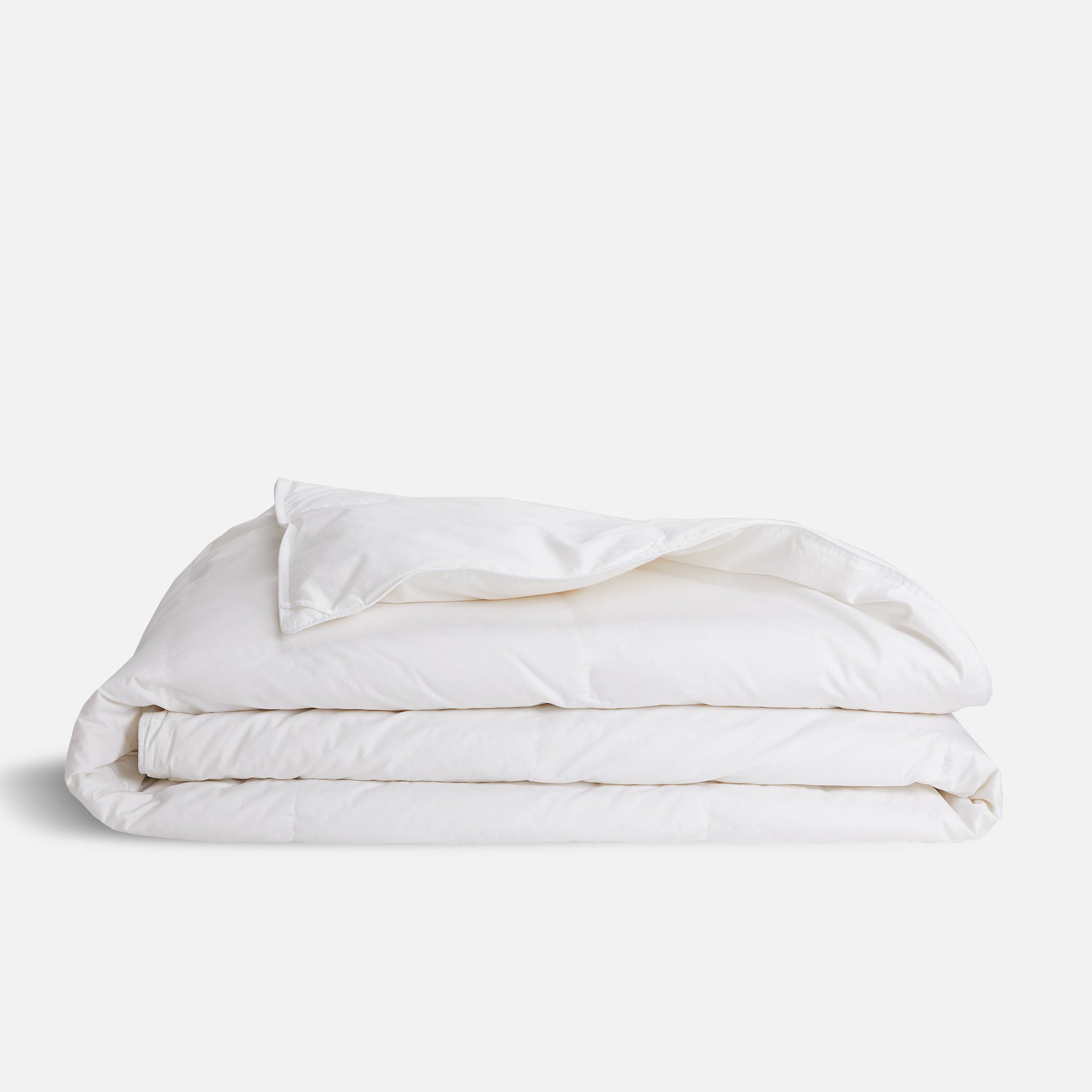 Brooklinen lightweight down comforter on neutral bedroom setup
